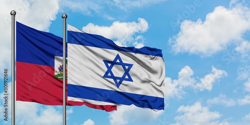 Haiti and Israel flag waving in the wind against white cloudy blue sky together. Diplomacy concept, international relations.