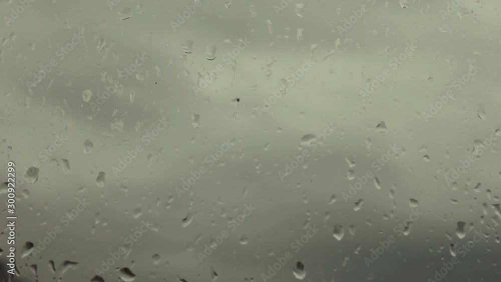 The rain outside the window in the autumn or winter, view to a cloudy sky. Wet window in drops of water. Natural background, texture, abstraction The rain outside the window in the autumn or winter, view to a cloudy sky. Wet window in drops of water. Natural background, texture, abstraction