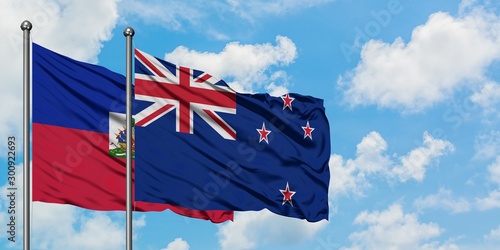 Φωτογραφία Haiti and New Zealand flag waving in the wind against white cloudy blue sky together