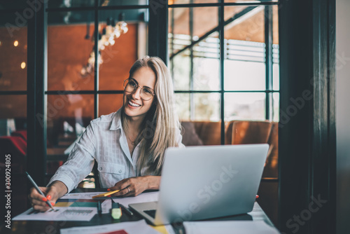 Happy young woman with papers and laptop