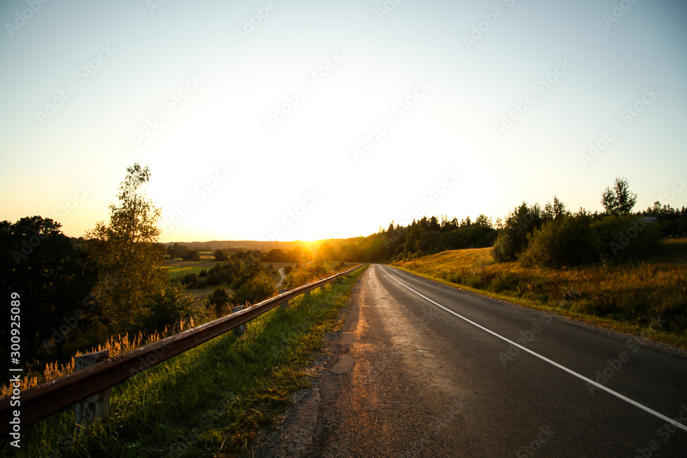 Beautiful summer autumn view of sunset viwth asphalt road near amazing sun view in the evening. 