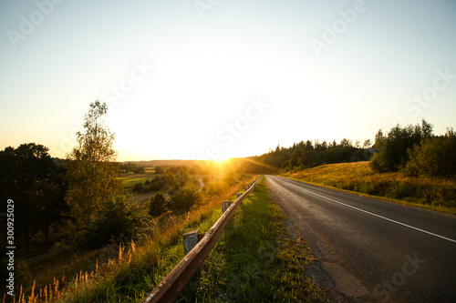 Beautiful summer autumn view of sunset viwth asphalt road near amazing sun view in the evening.  photo