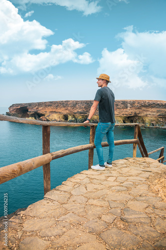 Canvastavla Hombre con sombrero en mirador acantilado en paz