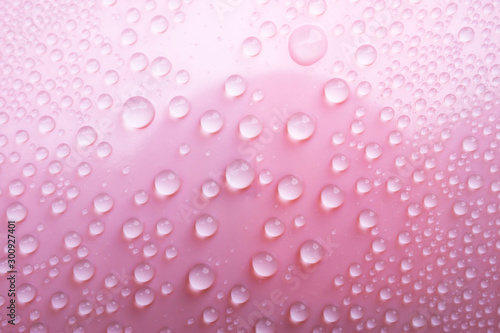 Water droplet on pink texture surface.