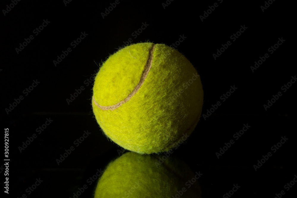 Tennis ball on a black mirror background. Reflection of a tennis ball.