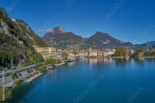 Aerial view of the city of Riva del Garda, Italy. Panoramic view of Lake Garda in the foreground, the city is surrounded by rocks and alpine mountains. Autumn season.