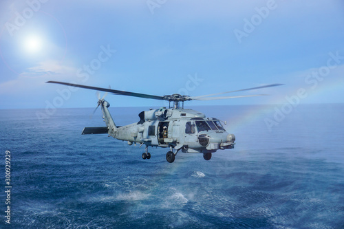 Military navy helicopter flying above the ocean.Copy space and background.