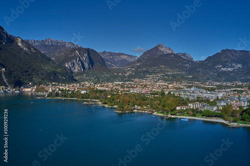 Aerial view of the city of Riva del Garda, Italy. Panoramic view of Lake Garda in the foreground, the city is surrounded by rocks and alpine mountains. Autumn season.