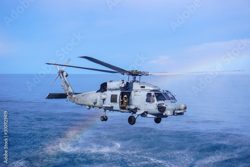 Fototapeta Naklejka Na Ścianę i Meble -  Military navy helicopter flying above the ocean.Copy space and background.