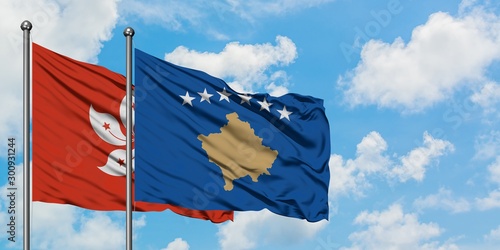 Hong Kong and Kosovo flag waving in the wind against white cloudy blue sky together. Diplomacy concept, international relations.