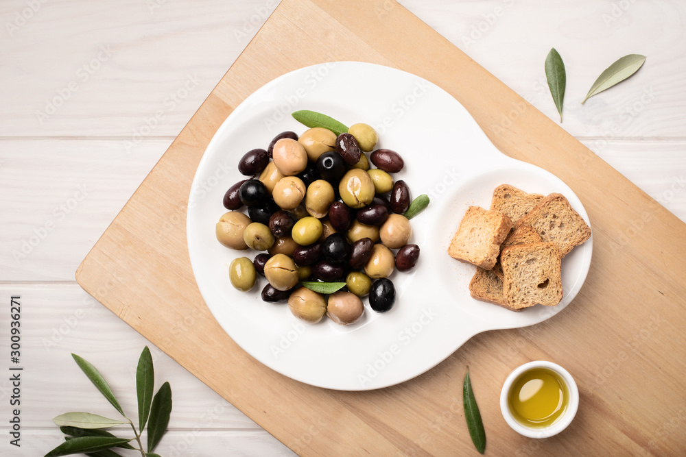Marinated olives in plate on wooden table. Tasty mediterranean food. Marinated olives in plate on wooden table. Tasty mediterranean food.
