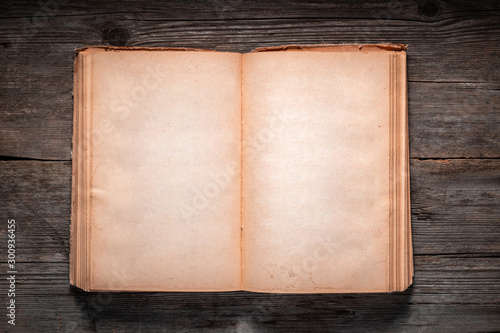 Фотография Vintage book, open, on old wooden table, with clipping path