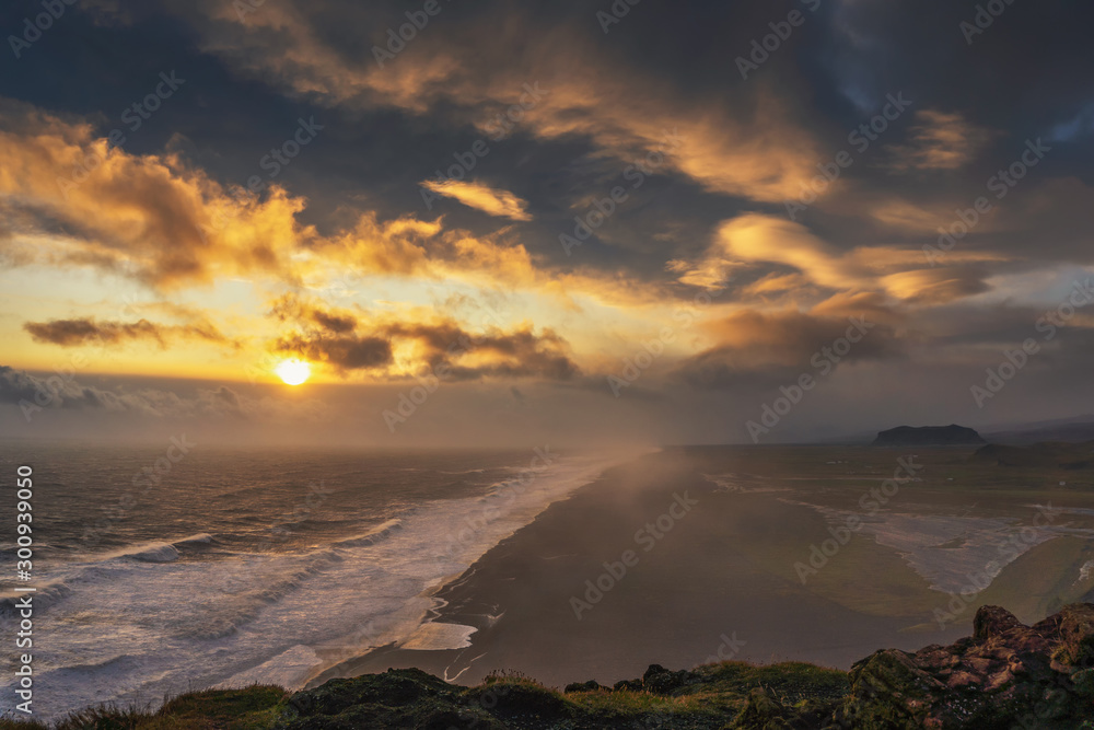 Dramatic sunset above a black beach viewed from Dyrholaey viewpoint in Iceland