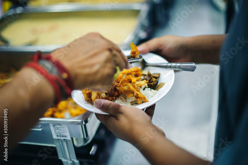 Homeless people receive food from volunteers: the concept of feeding