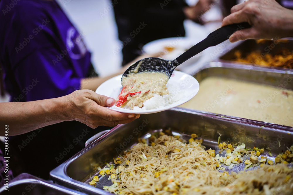 Homeless people receive food from volunteers: the concept of feeding foto  de Stock | Adobe Stock