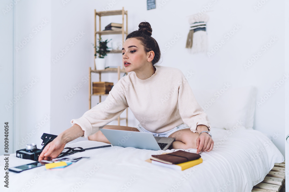 Enthusiastic young woman working with laptop and reach after mobile phone at home Enthusiastic young woman working with laptop and reach after mobile phone at home