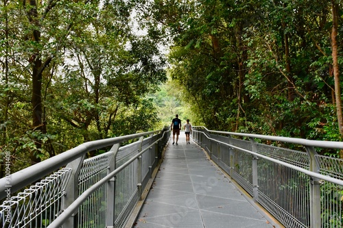 young couple walking on metal bridge on the Southern Ridges trail in Singapore