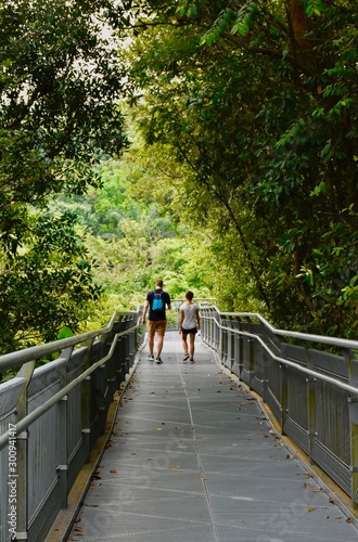 young couple walking on metal bridge on the Southern Ridges trail in Singapore