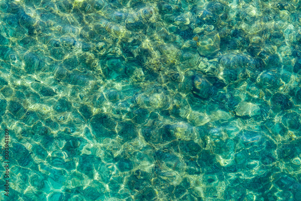 The water surface of the sea is emerald-colored. Through a layer of clear water you can see the bottom. Shooting from a drone. The water surface of the sea is emerald-colored. Through a layer of clear water you can see the bottom. Shooting from a drone.