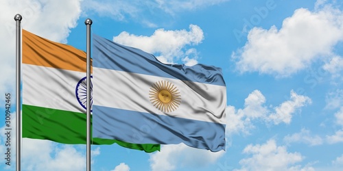 India and Argentina flag waving in the wind against white cloudy blue sky together. Diplomacy concept  international relations.