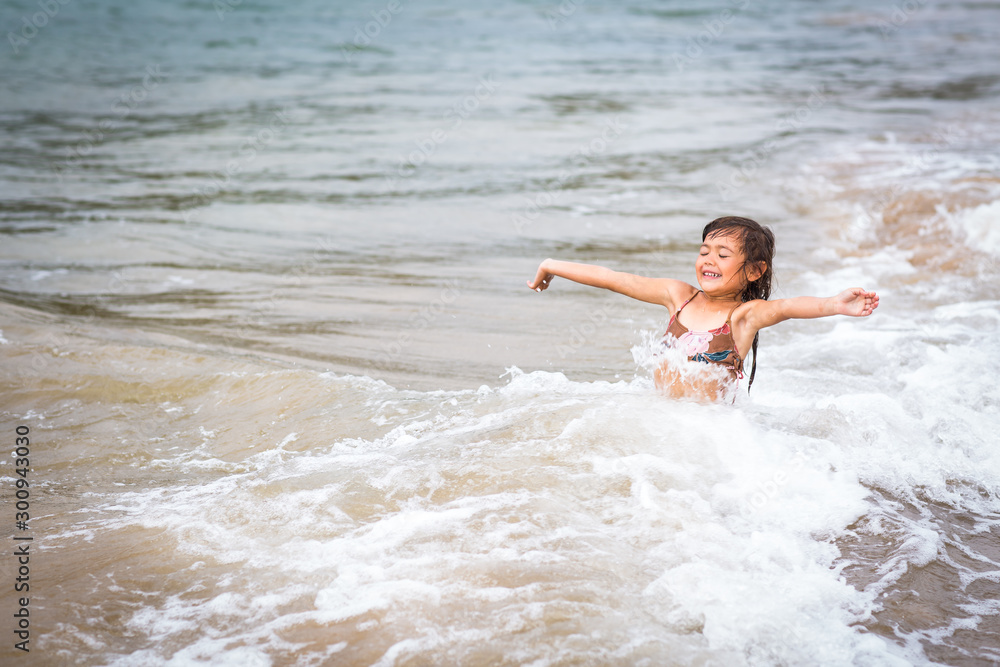 young girl full of joy arms out in the ocean