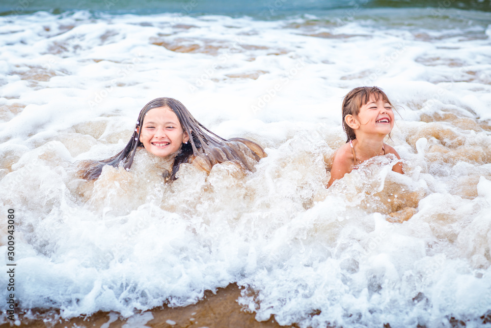 Two young girls playing in the Pacific Ocean Two young girls playing in the Pacific Ocean