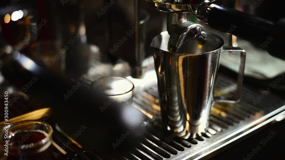 Coffee series: Barista taking metal cup out of coffee machine Coffee series: Barista taking metal cup out of coffee machine