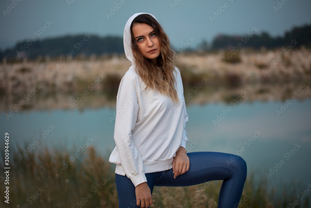 young woman sitting on a rock - Stock Image young woman sitting on a rock - Stock Image
