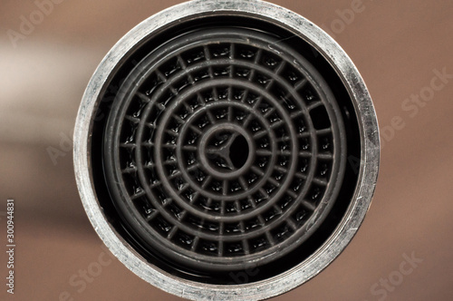 Plastic aerator built into the faucet to save water. Close-up, macro shot. photo