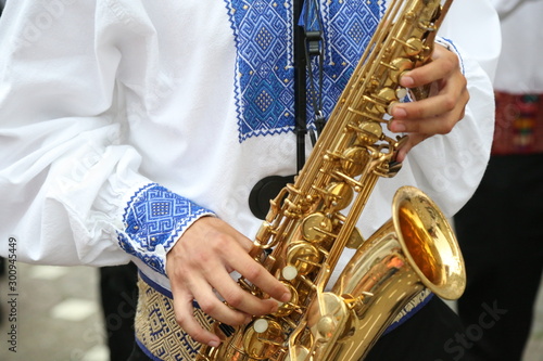 Folklore artist play saxophone wearing beautiful traditional costume.
