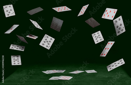 playing cards fall on a little kitten sitting on a green table photo