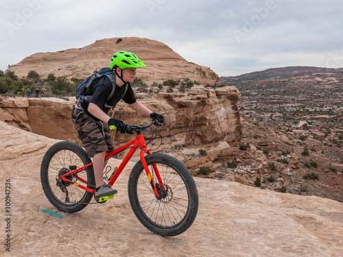 Obraz na płótnie Young boy riding a mountain bike on singletrack in Moab, Utah w salonie