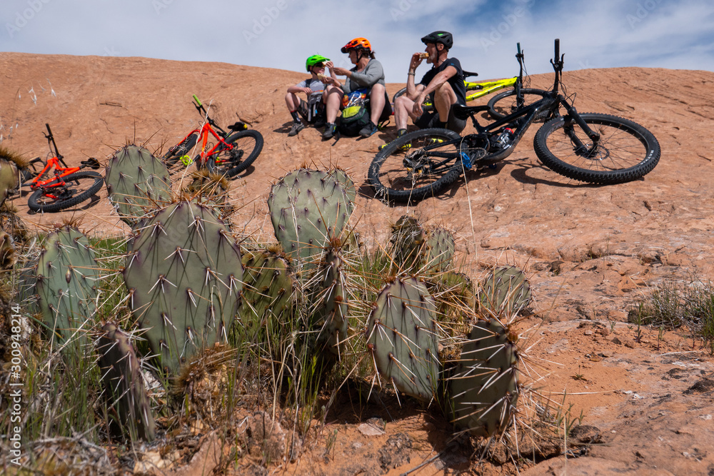 Son, mother and grandfather taking a break while riding mountain bikes of singletrack in Moab, Utah