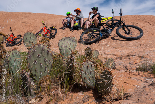 Obraz na płótnie Son, mother and grandfather taking a break while riding mountain bikes of singletrack in Moab, Utah w salonie