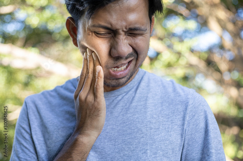 young asian man feeling pain suffering from bad toothache