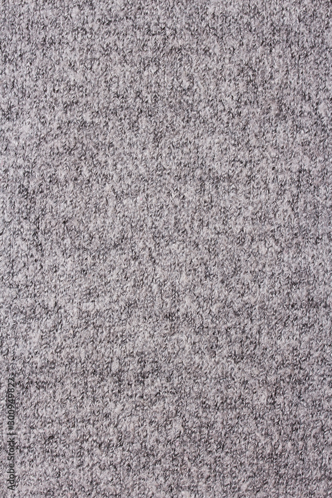 Fototapeta premium Background of grey knitted fabric. Home made stitchwork.