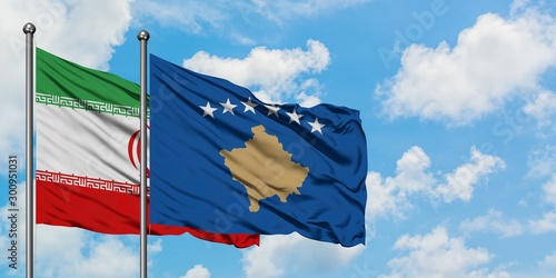 Iran and Kosovo flag waving in the wind against white cloudy blue sky together. Diplomacy concept, international relations.