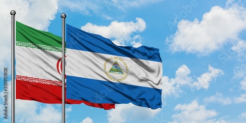 Iran and Nicaragua flag waving in the wind against white cloudy blue sky together. Diplomacy concept, international relations.
