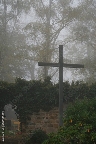 Friedhof im Nebel mit Gedenkstätte für die Kriegsopfer der beiden Weltkriege...