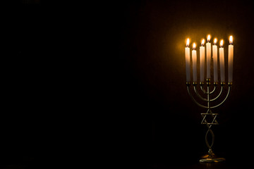 Jewish Hanukkah menorah on black background. Copy space	