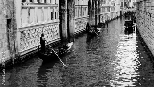 Black and white photo of gondola and gondolier taken in the beautiful city of Venice, Italy
