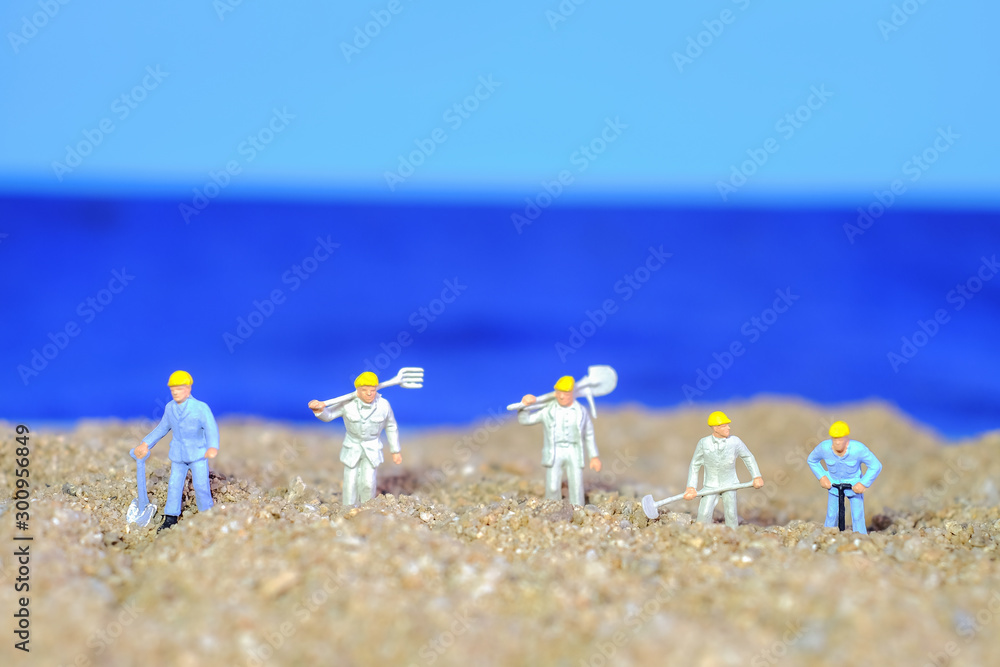 Miniature worker on sea beach.