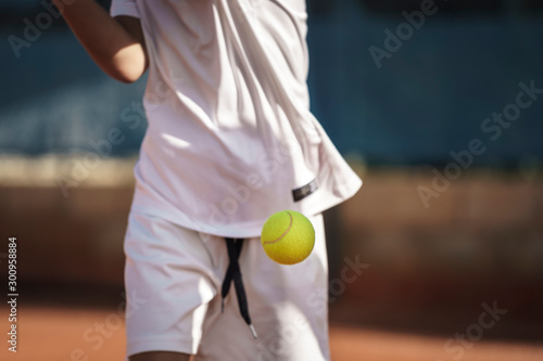 8 years old boy playing tennis, ball freezed © Nicolas Viard
