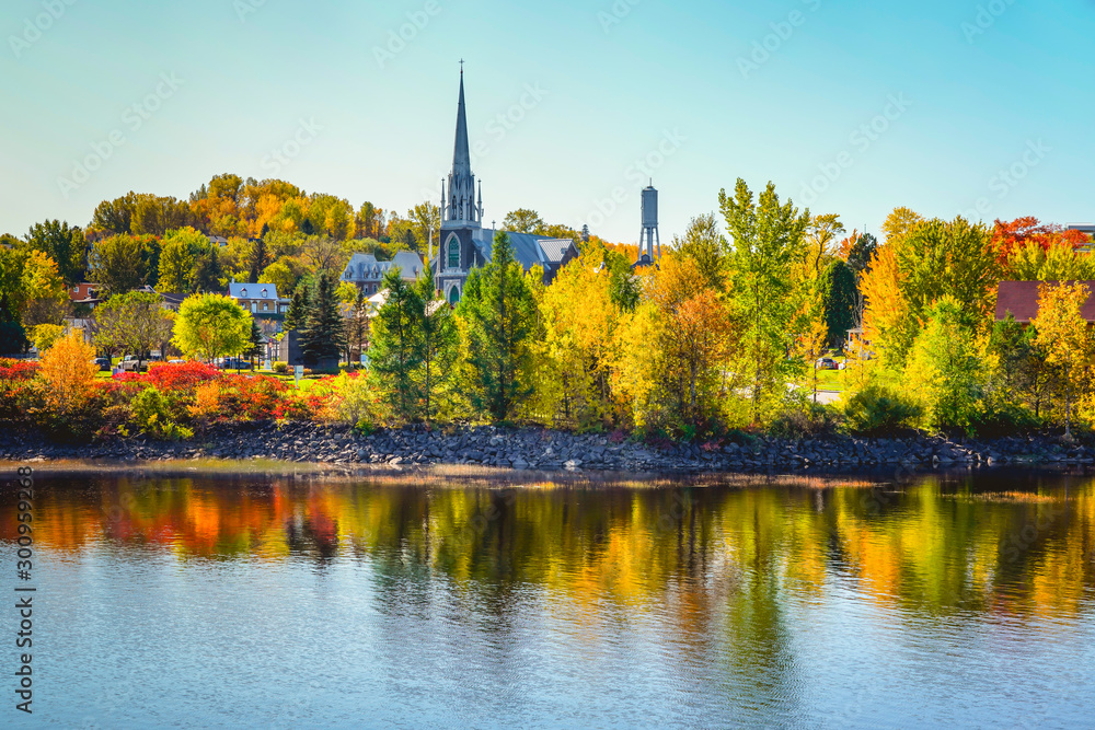 Fototapeta premium Autumn Landscape View with Church and Colorful Trees Reflected in Water
