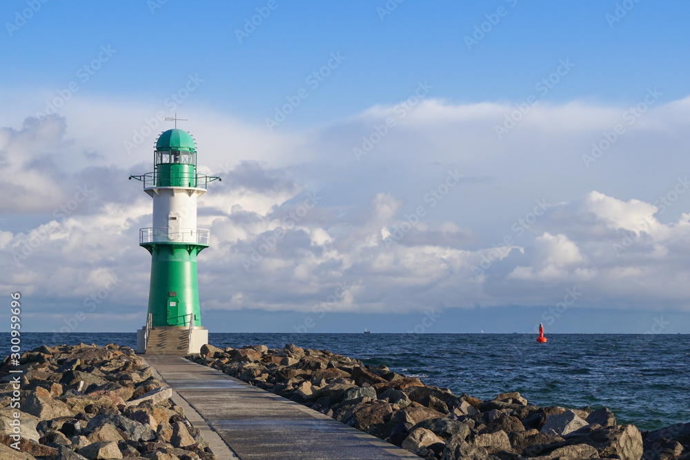 The green small lighthouse at the end of the breakwater in Warnemünde