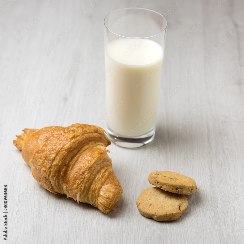 A croissant, some cookies and a glass of milk A croissant, some cookies and a glass of milk