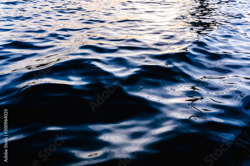 Natural seawater background with its intense bluish liquid texture at sunset.
