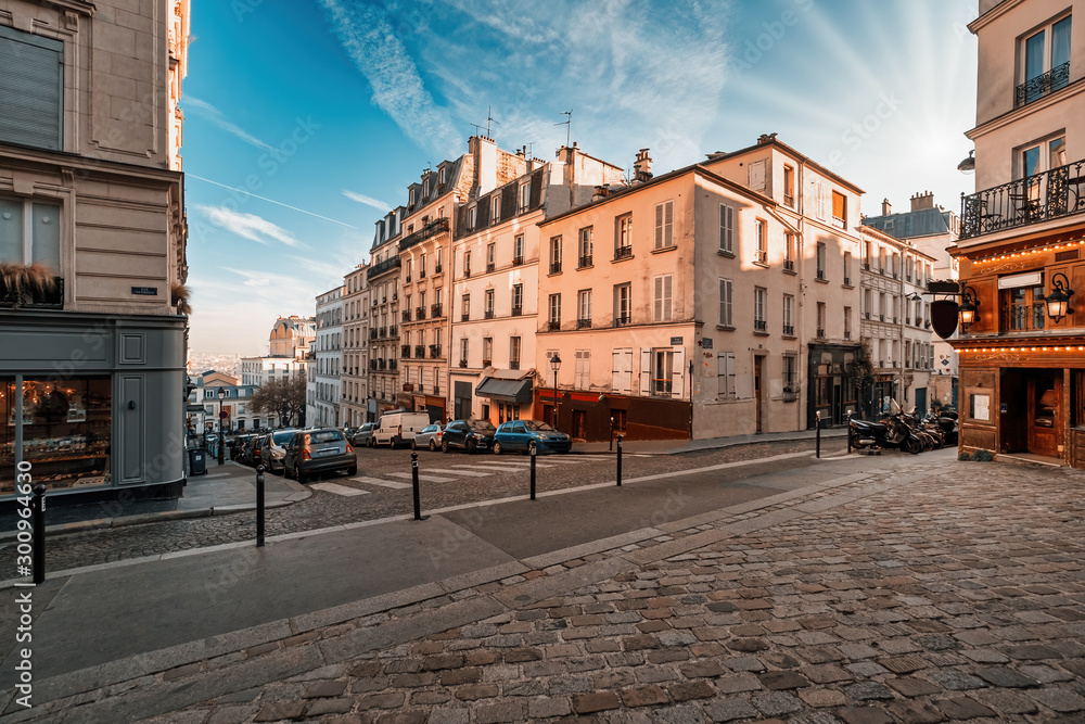 Fototapeta premium Ulice dzielnicy Montmartre w Paryżu, Francja. Poranne światło z niebieskim niebem.