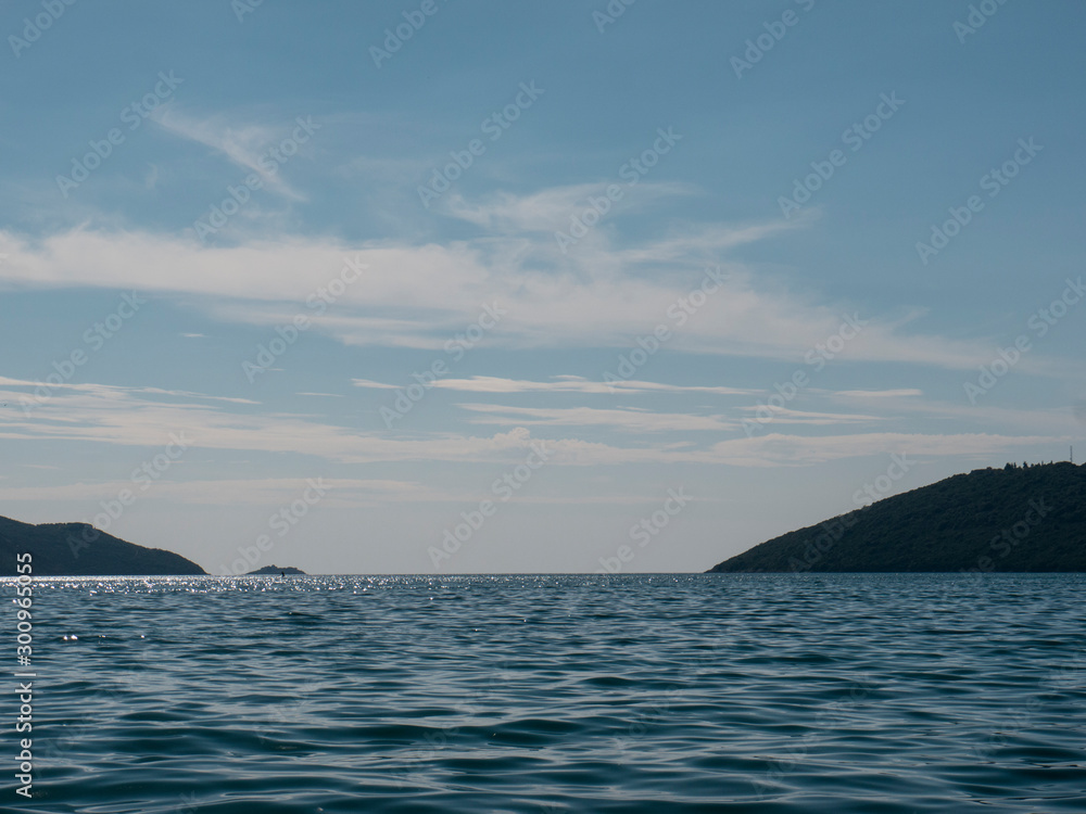 Sea surface under skies with mountains on background Sea surface under skies with mountains on background