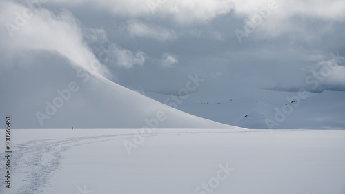 Snowy mountain landscape in the arctic with tracks in the front